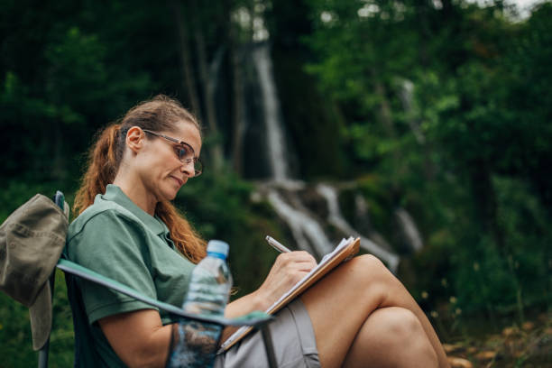 istock Woman biologist taking notes by the waterfall 1169748226