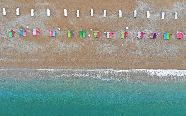 istock Aerial. Sea beach with colorful deck chairs. Top view from drone. 1169748310