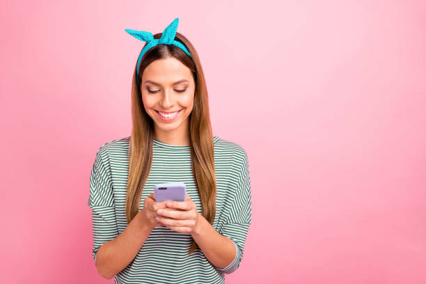 Pretty lady holding telephone hands toothy smiling wear striped pullover isolated pink background