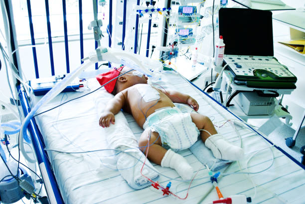A critically sick baby hooked on a ventilator in a hospital intensive care ward stock photo
