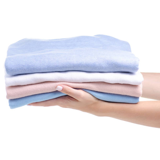istock Stack folded shirt clothing, pastel color hand holding 1169752644