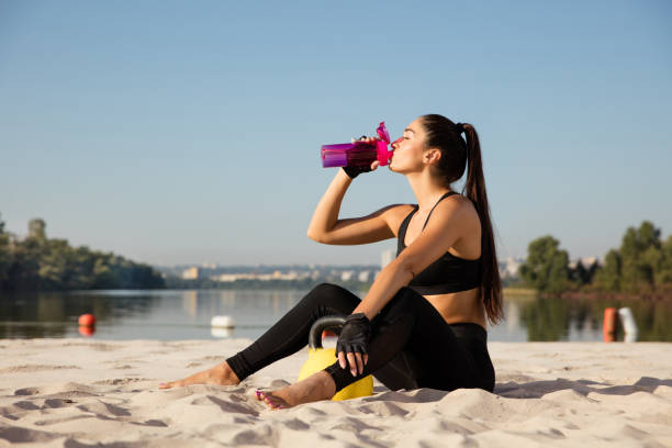 istock Young healthy female athlete doing workout at the beach 1169752806