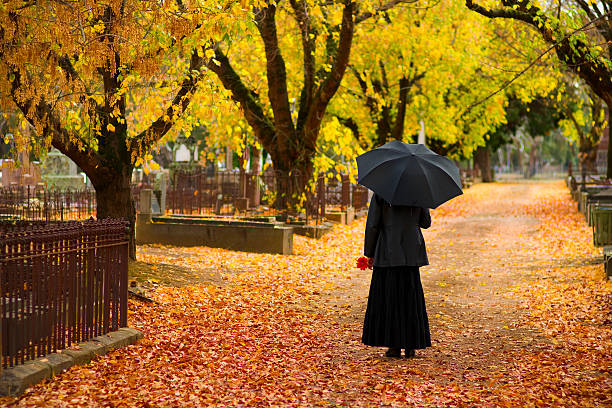 deuil noir femme portant dans un cimetière à l'automne - footpath autumn stone old photos et images de collection