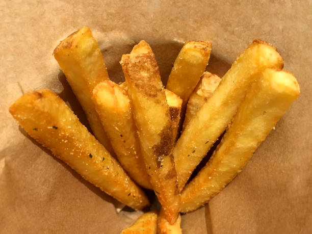 istock Deep fired potato stick french fries inside brown paper package 1169757368