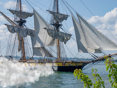 Reenactment of tall pirate sailing ship firing its cannons