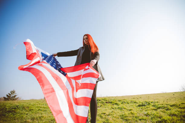 istock Young redhead spreading American flag 1169759044
