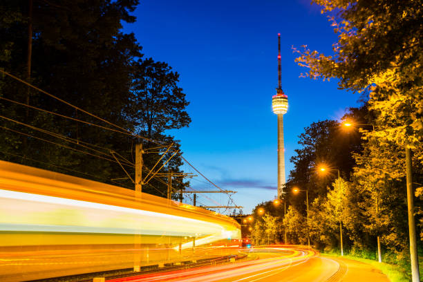 istock Germany, Stuttgart television tower and tramway illuminated by night at road with traffic and starry sky in summer surrounded by forest nature landscape 1169759738