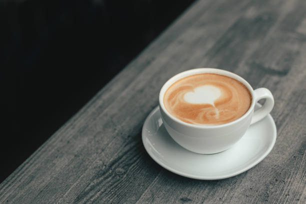 istock Cup of coffee with latte art on wooden table. 1169766194