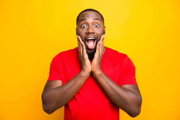 istock Photo of excited ecstatic rejoicing overjoyed black man admiring something adoring while isolated with yellow background 1169767181
