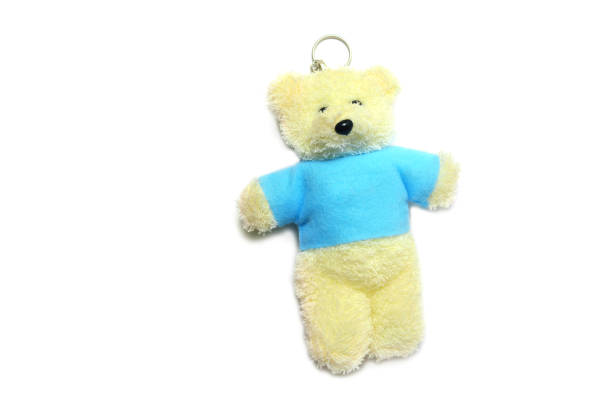 a yellow bear doll with blue clothes standing on white background isolated a yellow bear doll with blue clothes standing on white background isolated behavior teddy bear doll old stock pictures, royalty-free photos & images
