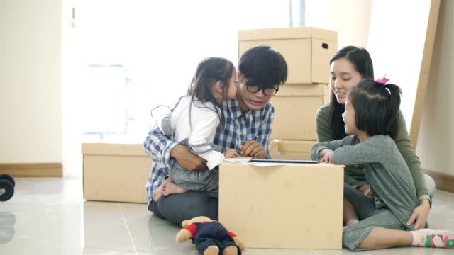 Family moving to new home and using tablet for decorate house with child , slow motion