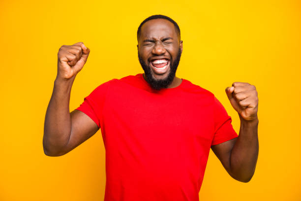 istock Photo of bearded overjoyed ecstatic man having won some competitions while isolated with yellow background 1169767524