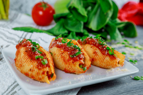 istock Pasta shells stuffed with ricotta cheeses, tomato sauce and chives. 1169768938