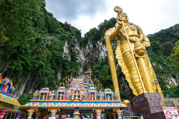 View of Batu Caves with the world's tallest Murugan statue, where is a limestone hill that has a series of caves and cave temples, in Selangor, Malaysia. stock photo
