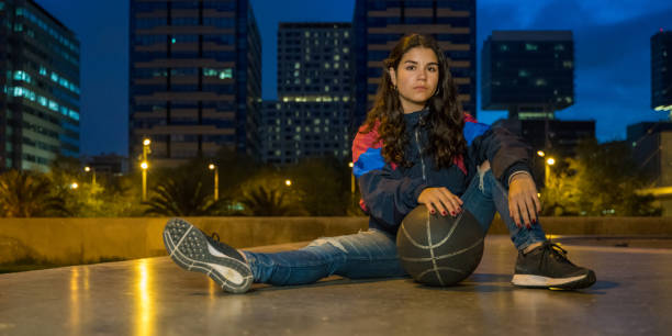 istock Cool young girl sitting with a basket ball 1169770492