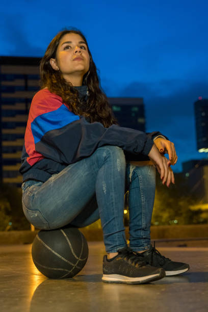 istock Cool young girl sitting with a basket ball 1169770516