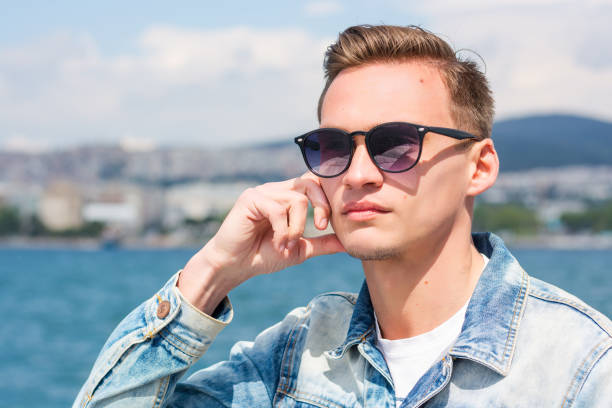 istock A young handsome man in sunglasses at the seascape 1169771104