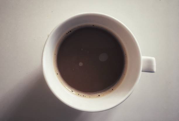 istock Hot 3 in 1 coffee with bubbles in white cup on white table background. 1169772990