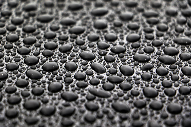 Large drops of water on a dark surface close-up