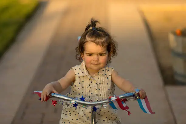High quality stock photos of a little girl riding a tricycle during a summertime sunset.