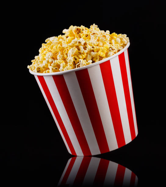 istock Paper striped bucket with popcorn isolated on black background 1169783772