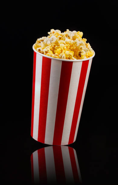 istock Paper striped bucket with popcorn isolated on black background 1169783783