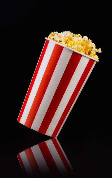 istock Paper striped bucket with popcorn isolated on black background 1169783795