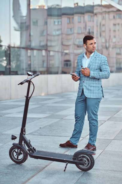 istock Handsome man is standing near his electro scooter 1169783805
