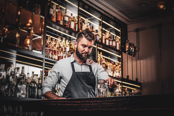 istock Attractive cheerful barmen is prepairing drinks 1169783929