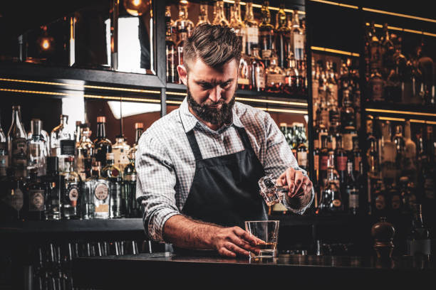 Attractive barmen is prepairing drinks stock photo