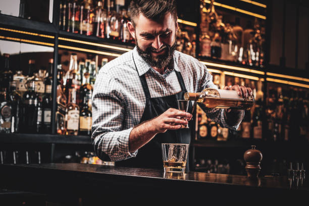 istock Attractive cheerful barmen is prepairing drinks 1169784253