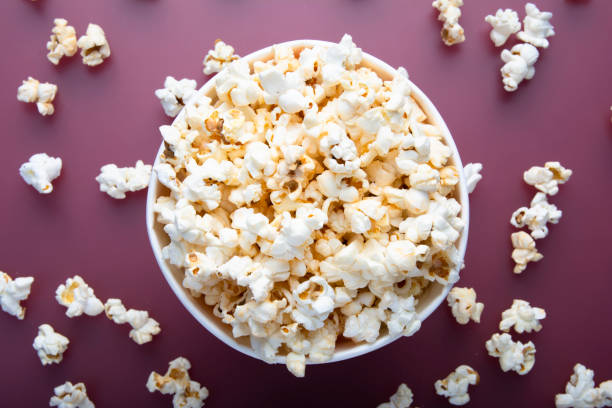istock Testy warm popcorn viewed from above on red background. Top view. Enterteinment concept 1169787453