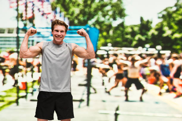 istock Handsome man is standing at an outside sporting event and cheering 1169788277