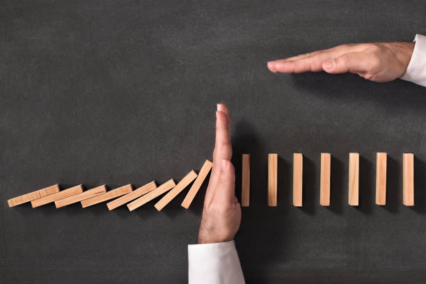 istock Domino Effect and Business Challenge Concept on Blackboard 1169791374