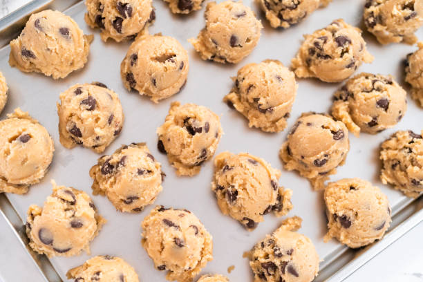 istock Homemade chocolate chip cookies dough scoops on a baking sheet. 1169792515