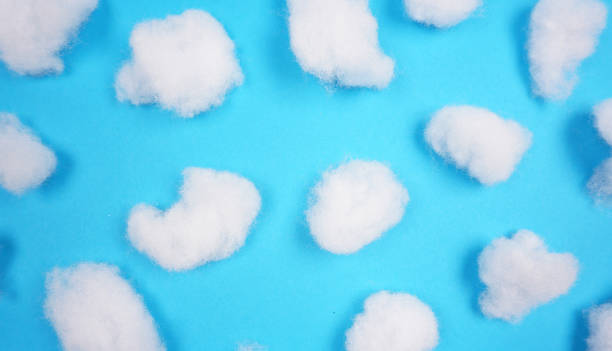 White cotton texture is soft, fluffy wadding at blue background (winter clouds) White cotton texture is soft, fluffy wadding at blue background (winter clouds, abstract) cotton swab photos stock pictures, royalty-free photos & images