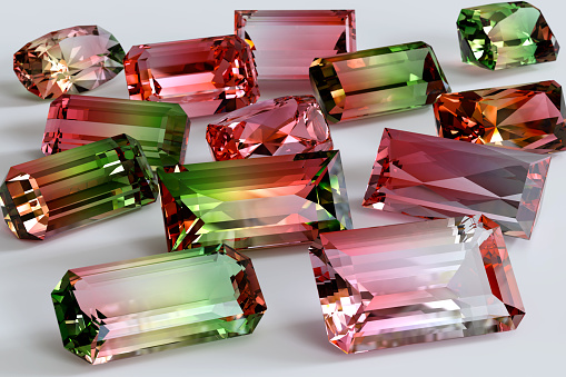Pile of variously cut dual colored, pink, green tourmaline stones.