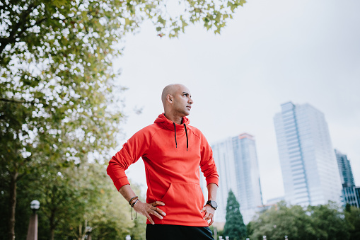 An Indian man goes for a morning run in the city of Bellevue, Washington, USA. Bellevue's Downtown Park is a perfect place for a jog or other exercise, with open footpaths and city skyline views.