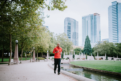 An Indian man goes for a morning run in the city of Bellevue, Washington, USA. Bellevue's Downtown Park is a perfect place for a jog or other exercise, with open footpaths and city skyline views.