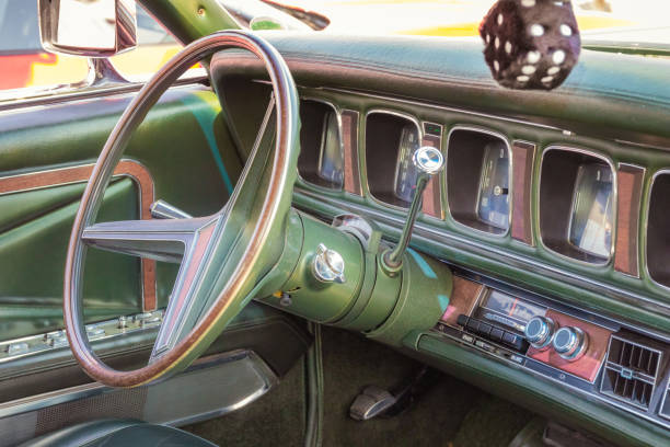 Green leather, wood and chrome interior of a classic american luxury oldtimer car. Steering wheel, radio, speedometer and a hairy dice - fotografia de stock