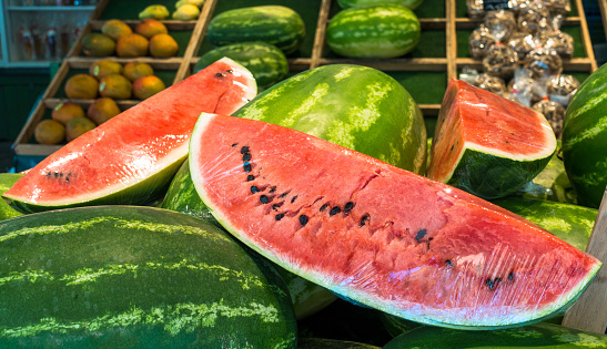 Fresh sweet watermelon on market stall as background. Ripe freshly picked water melons pile at farmers market