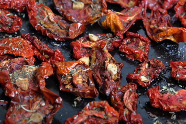 istock Sun-dried tomatoes with spices and garlic on a baking sheet. 1169797422