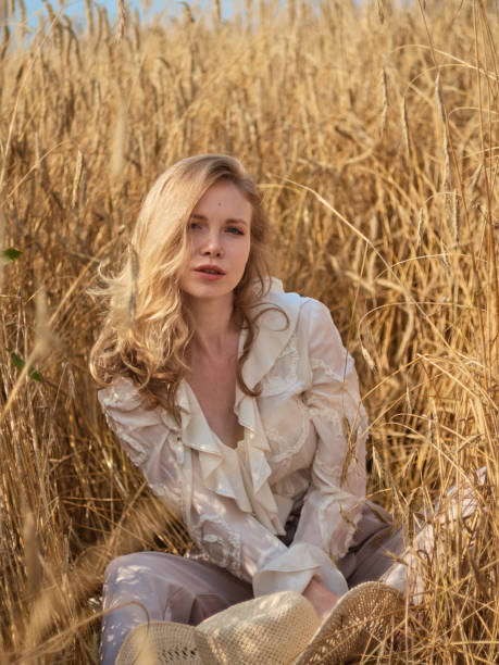 istock A blonde in a white blouse sits in a rye field 1169797432