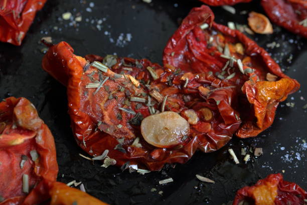 istock Sun-dried tomatoes with spices and garlic on a baking sheet. 1169797481