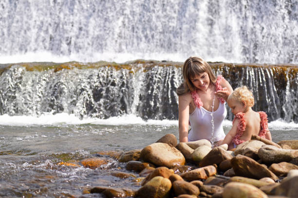 Permet, Albania A woman sits under a waterfall at the Benja Thermal Baths in the mountains.