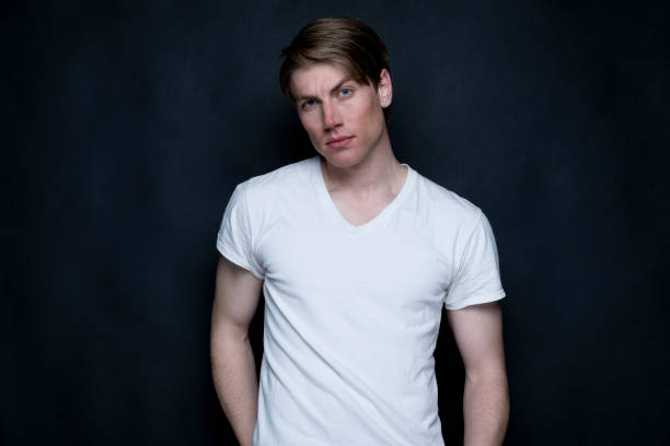 istock Handsome man wearing white tshirt on black background 1169800513