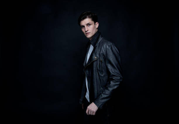 istock Good looking man wearing a leather jacket in front of black background 1169800992