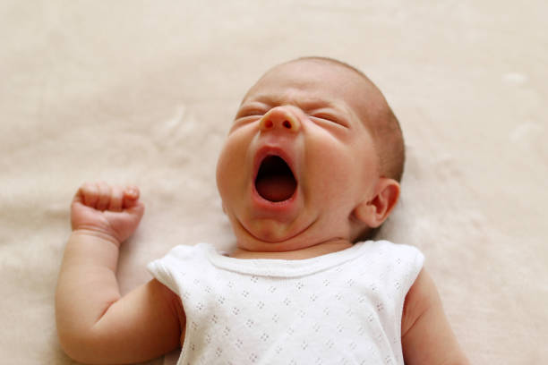 One month child is yawning lying on a blanket before go to sleep. One month child is yawning lying on a blanket before go to sleep. Only Baby Girls stock pictures, royalty-free photos & images