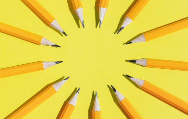 Circle of orange pencils on a yellow background