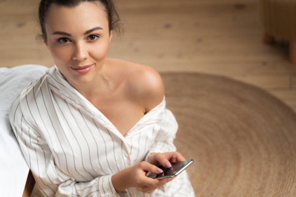 Beautiful young woman using mobile phone and smiling